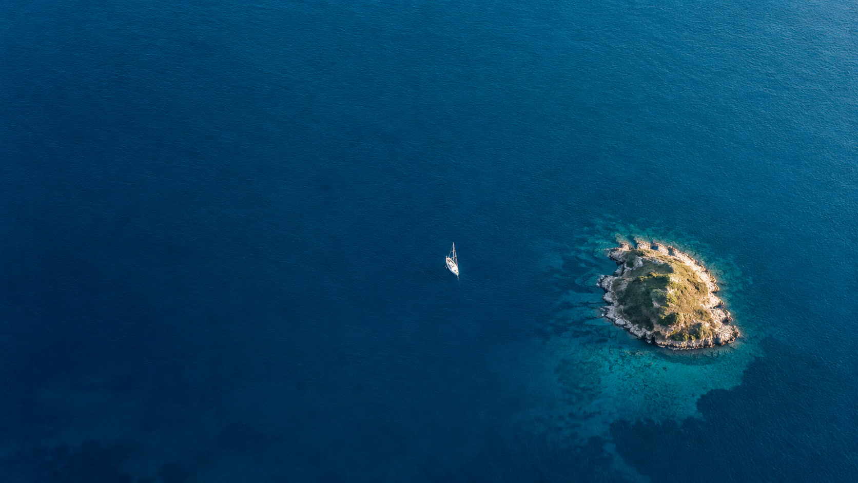 Aerial view of a small island surrounded by deep blue water.